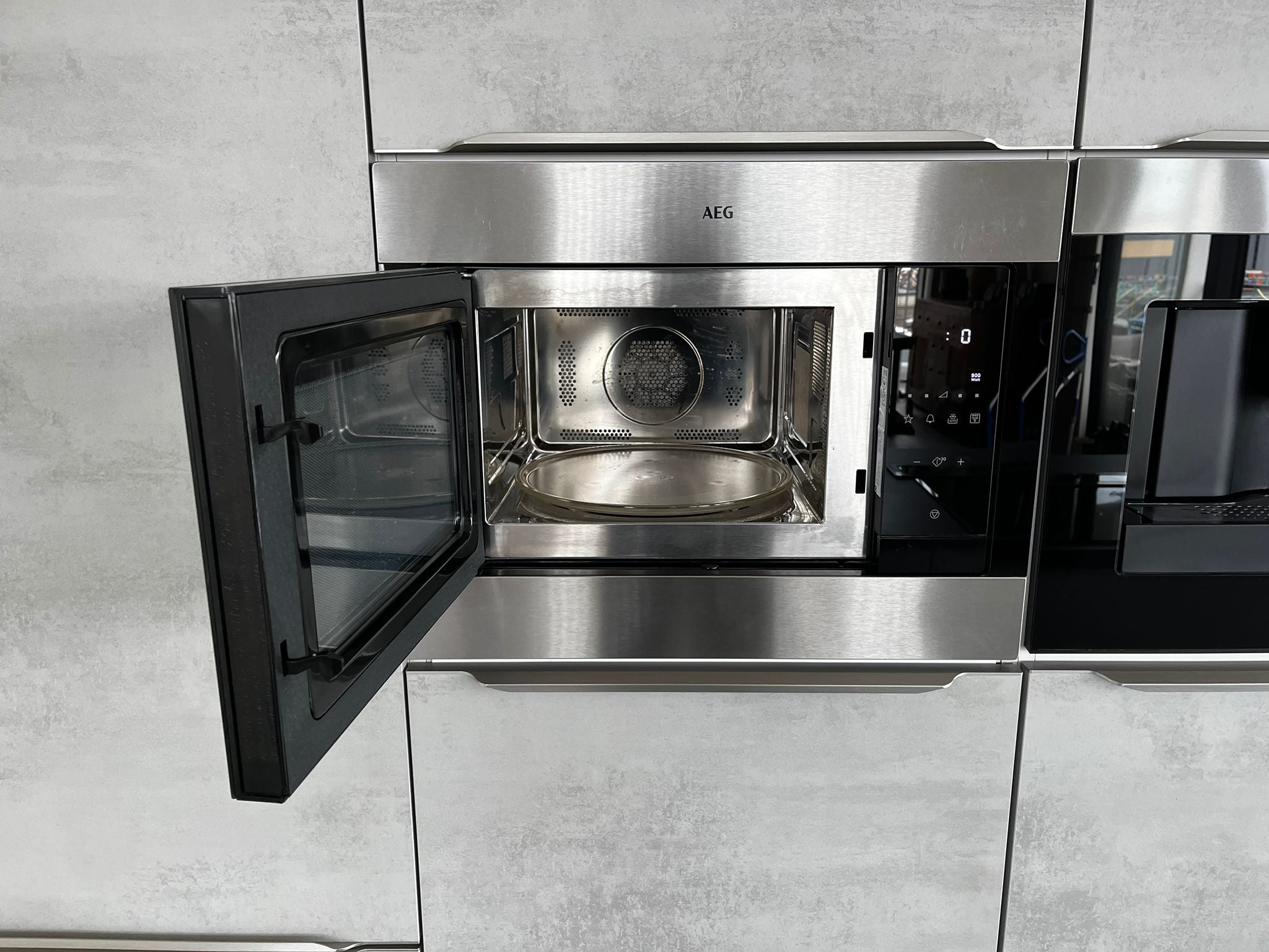Tweedehands zwart en grijze Nobilia StoneArt eilandkeuken oven open van AEG