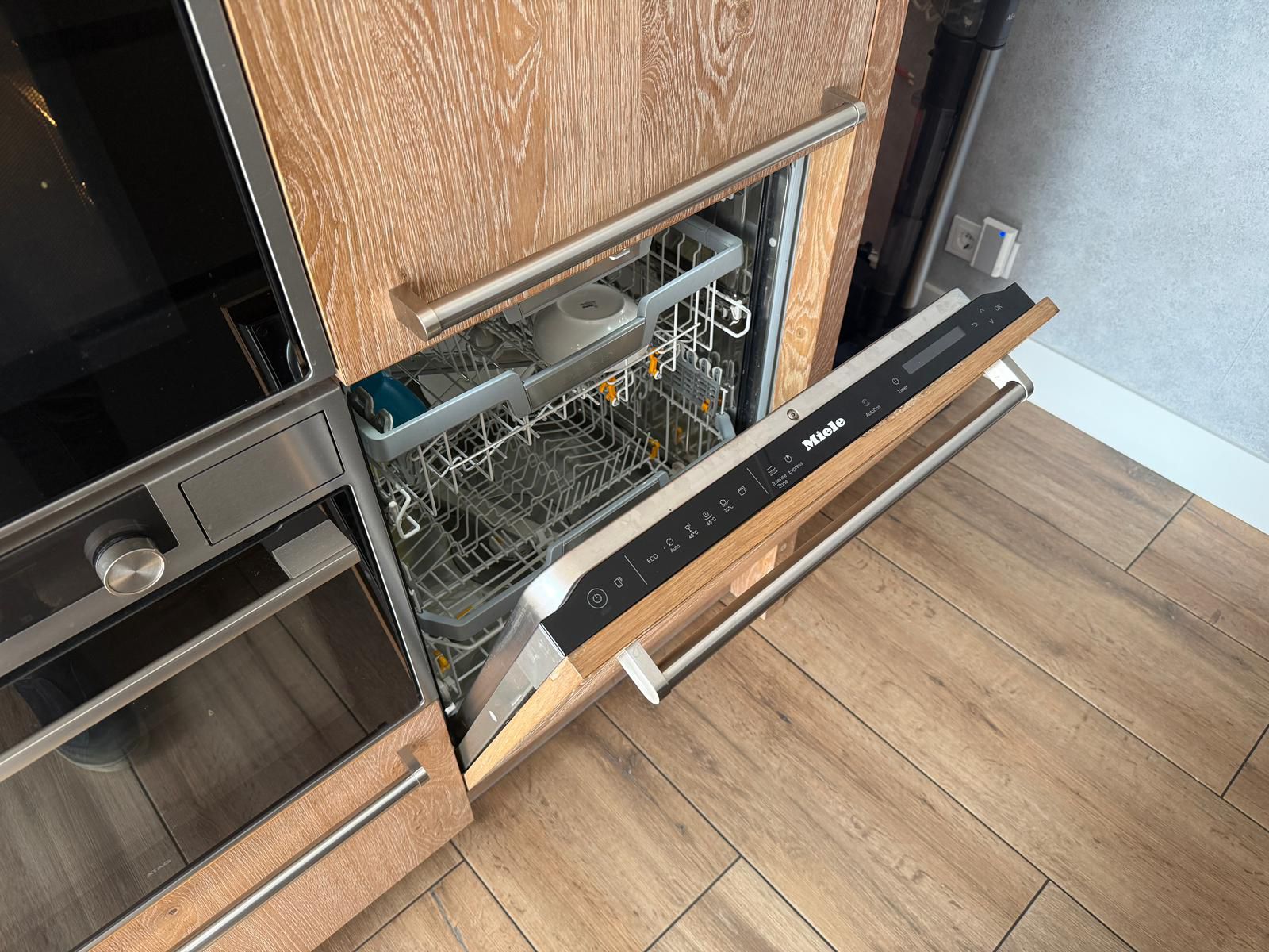 Tweedehandse keuken in houtlook met een grijs kookeiland en kunststoffen blad met een Miele vaatwasser