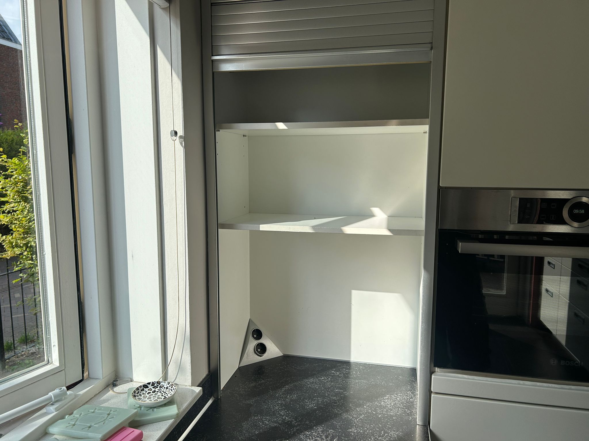 Witte tweedehandse keuken van het merk Alno met een wit schiereiland met een afschermbare kast