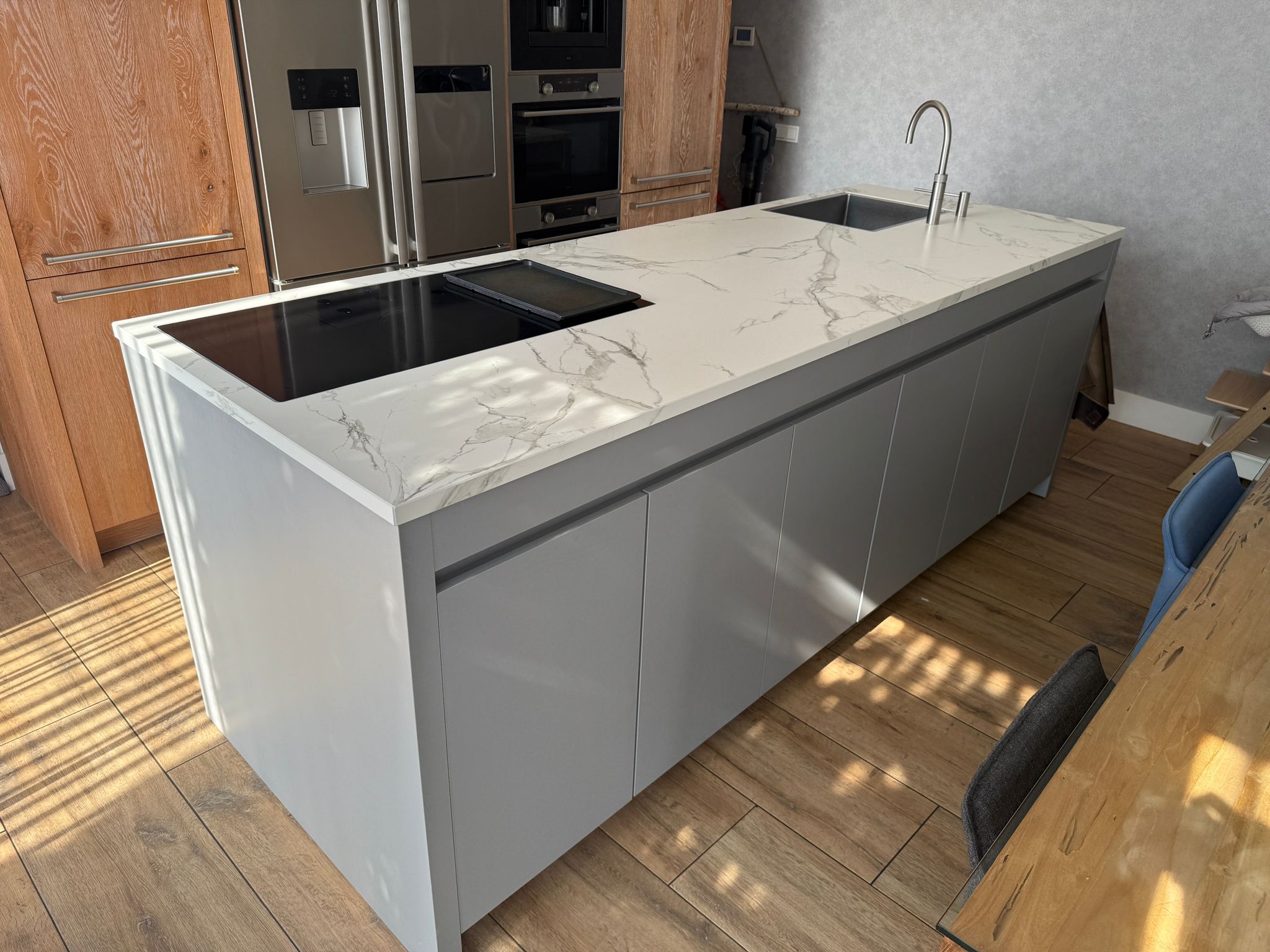Tweedehandse keuken in houtlook met een grijs kookeiland en kunststoffen blad gefocust op het eiland
