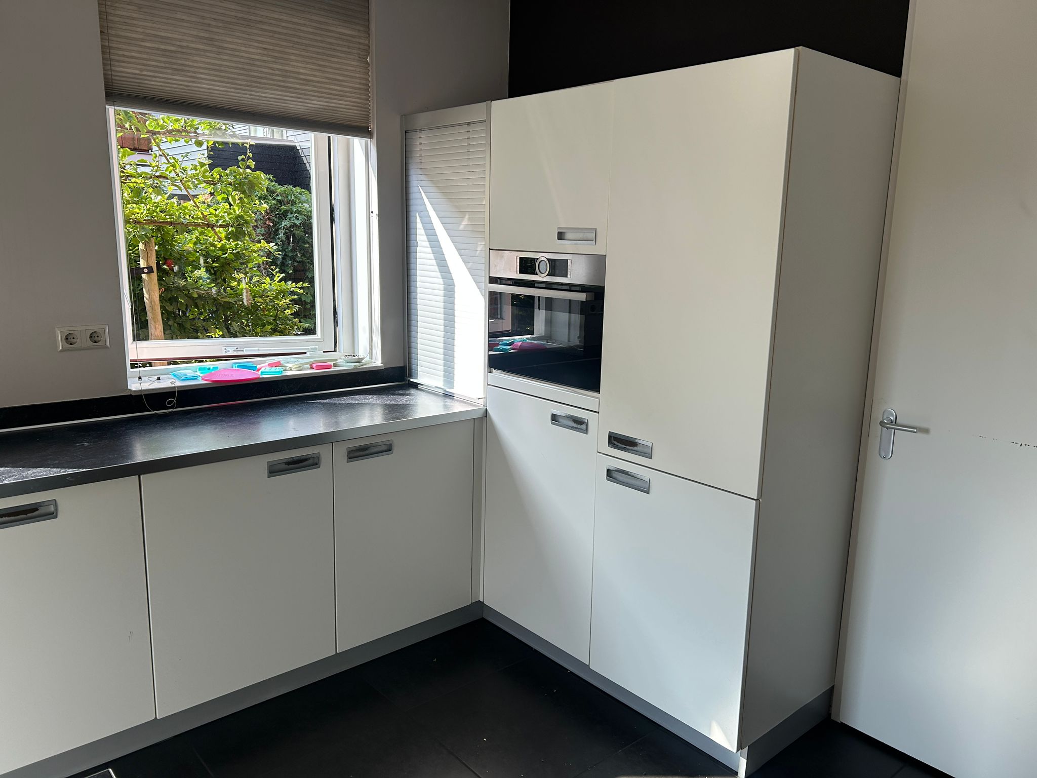 Witte tweedehandse keuken van het merk Alno met een wit schiereiland en een inbouw oven