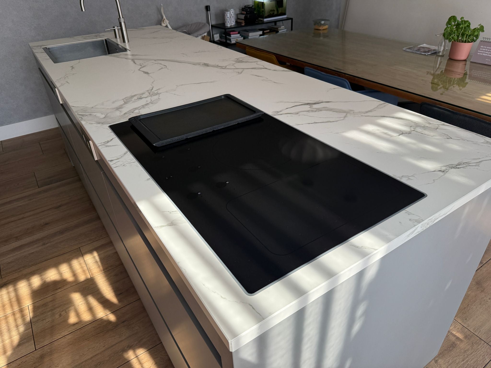 Tweedehandse keuken in houtlook met een grijs kookeiland en kunststoffen blad en inductiekookplaat