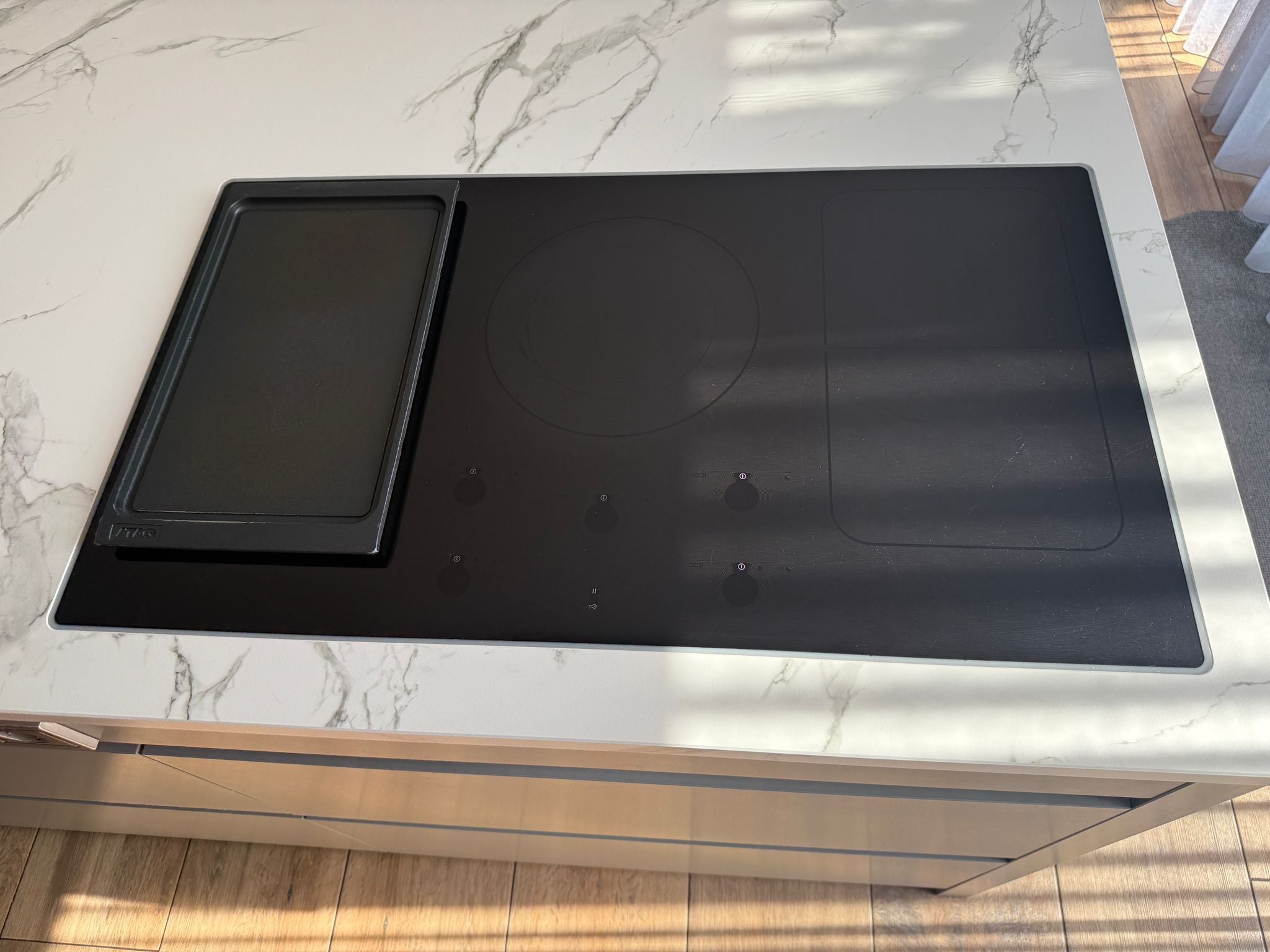 Tweedehandse keuken in houtlook met een grijs kookeiland en kunststoffen blad en inductieplaat
