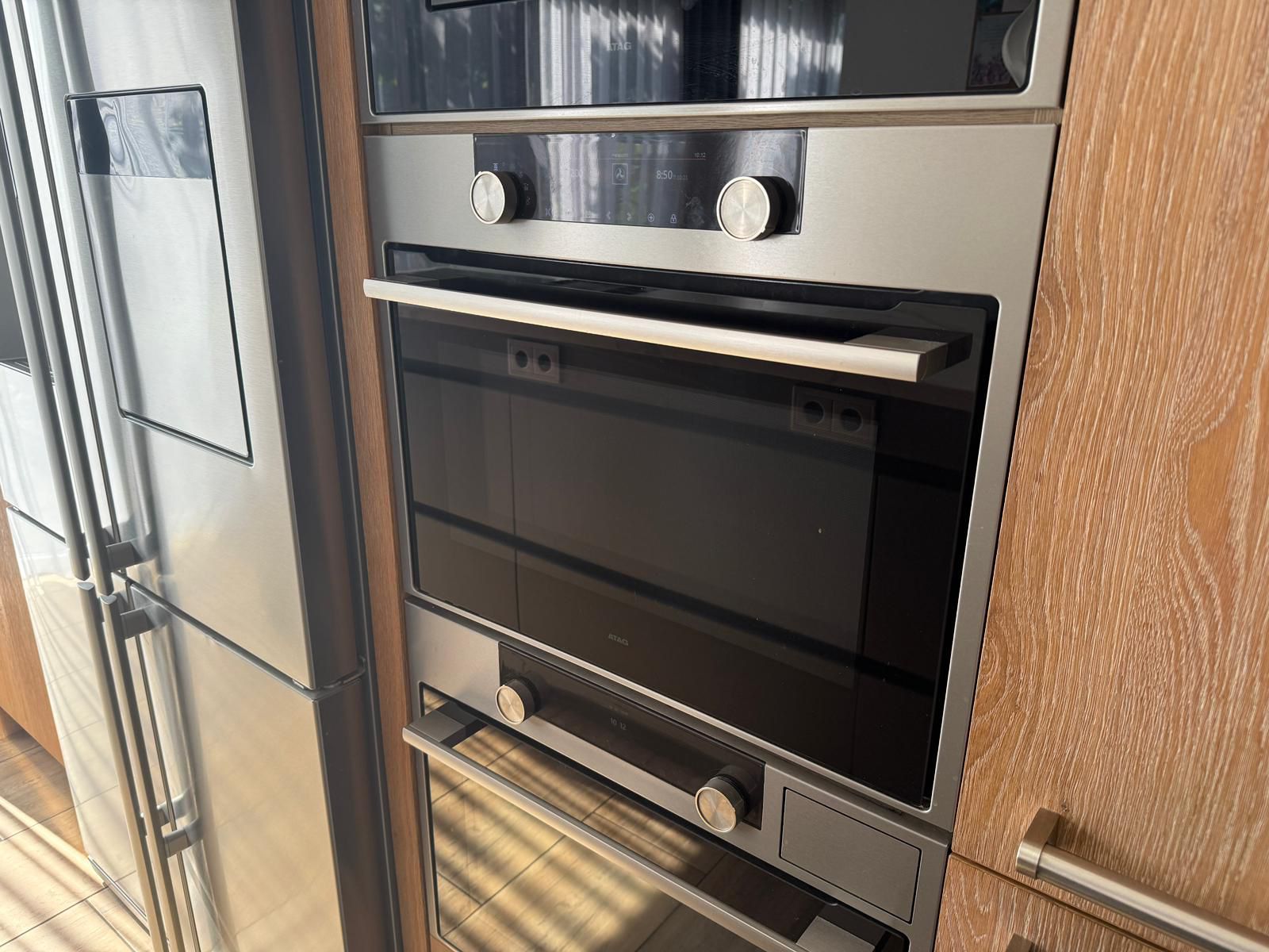 Tweedehandse keuken in houtlook met een grijs kookeiland en kunststoffen blad met ingebouwde oven