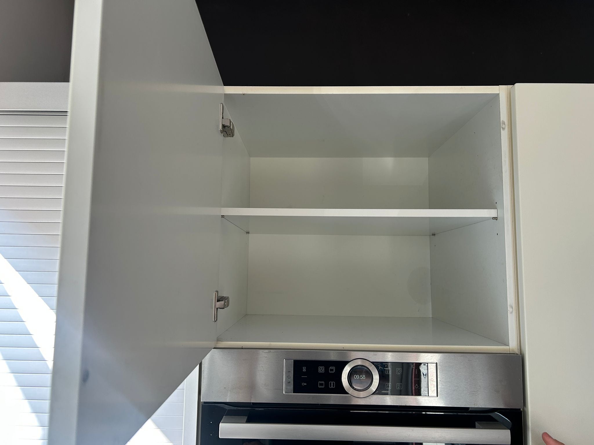 Witte tweedehandse keuken van het merk Alno met een wit schiereiland met kast boven de oven