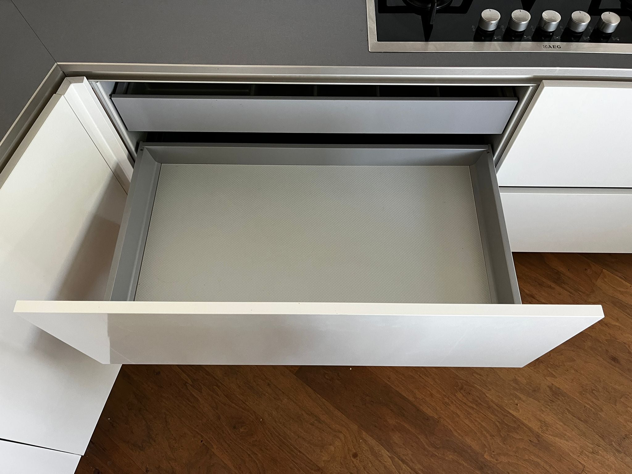 Witte hoekkeuken met ingebouwde AEG apparatuur keukenlade