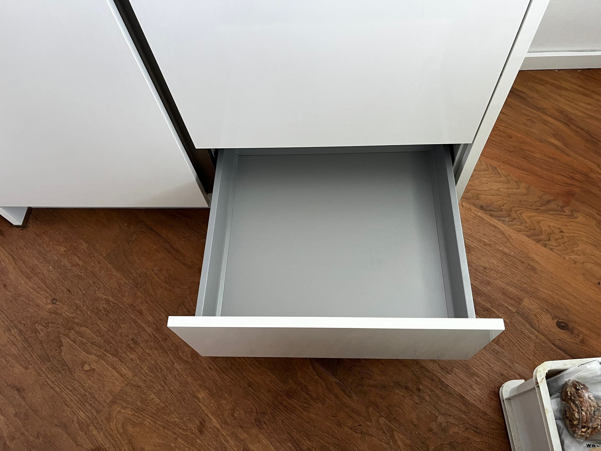 Witte hoekkeuken met ingebouwde AEG apparatuur met een lade onder de koelkast