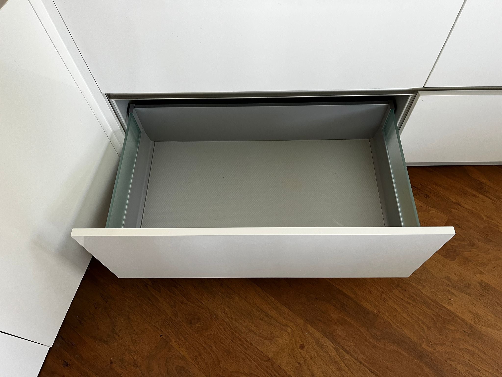 Witte hoekkeuken met ingebouwde AEG apparatuur met onderste keukenlade