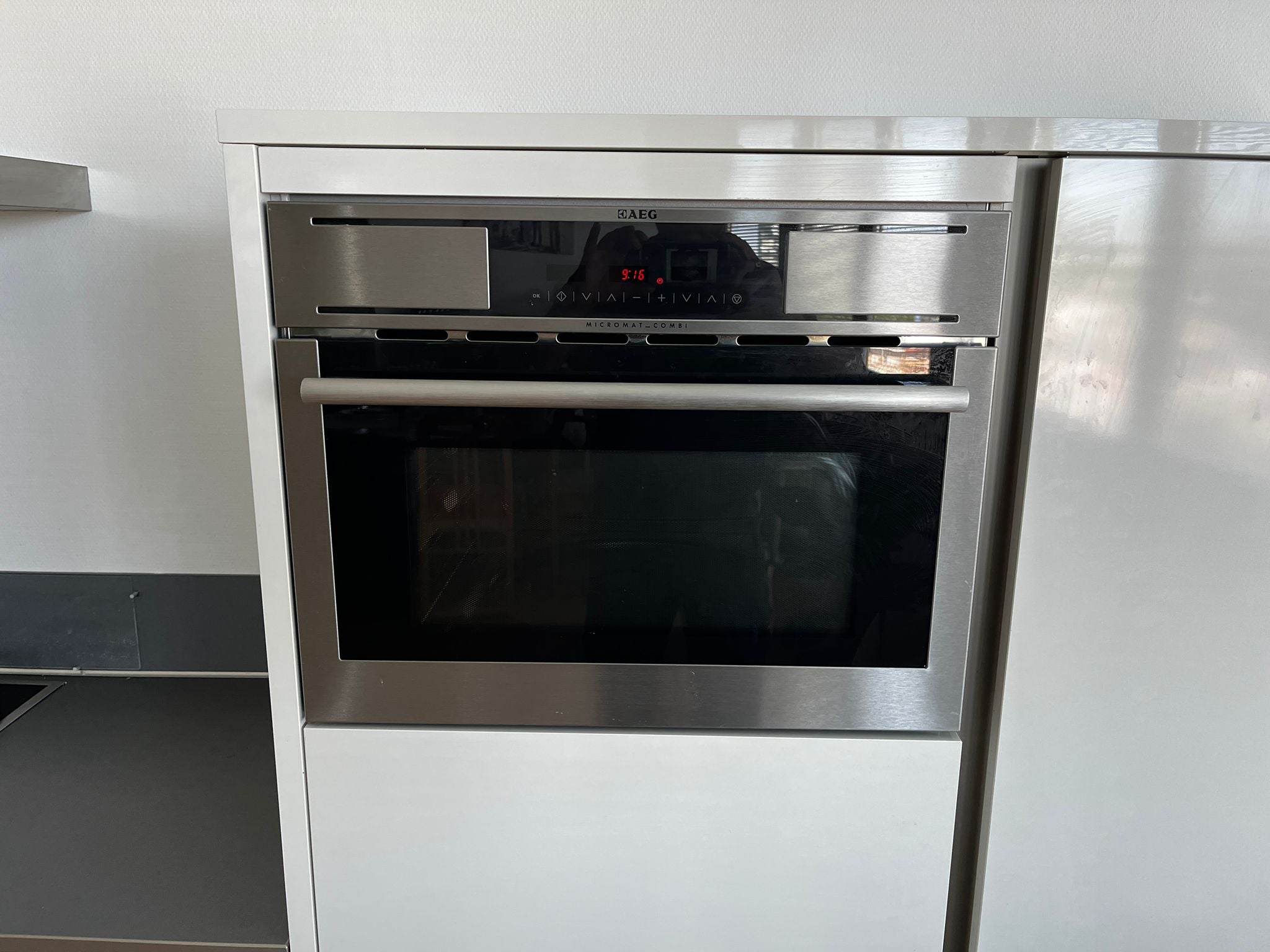 Witte hoekkeuken met ingebouwde AEG apparatuur en AEG oven