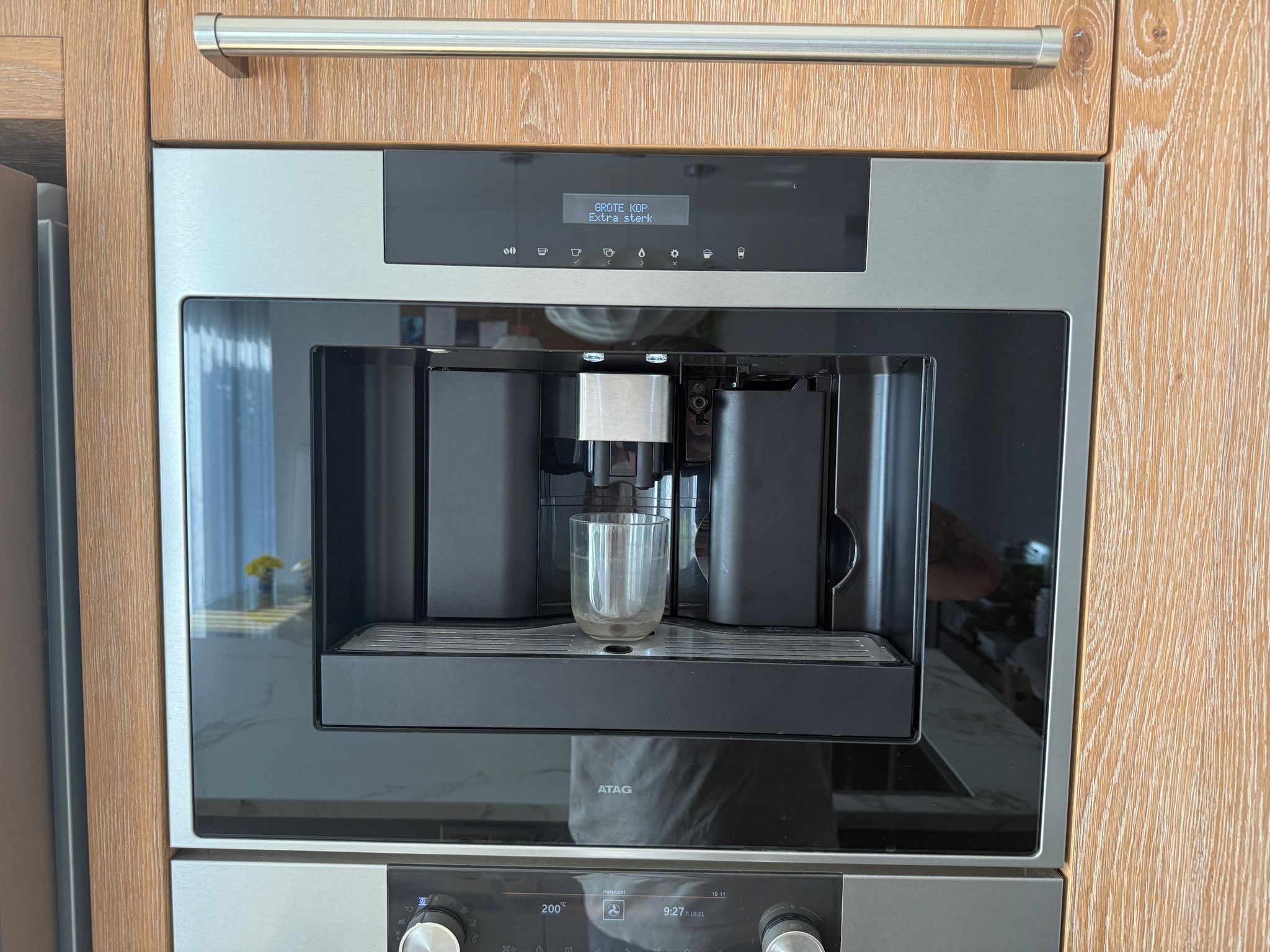 Tweedehandse keuken in houtlook met een grijs kookeiland en kunststoffen blad met koffieapparaat voorkant