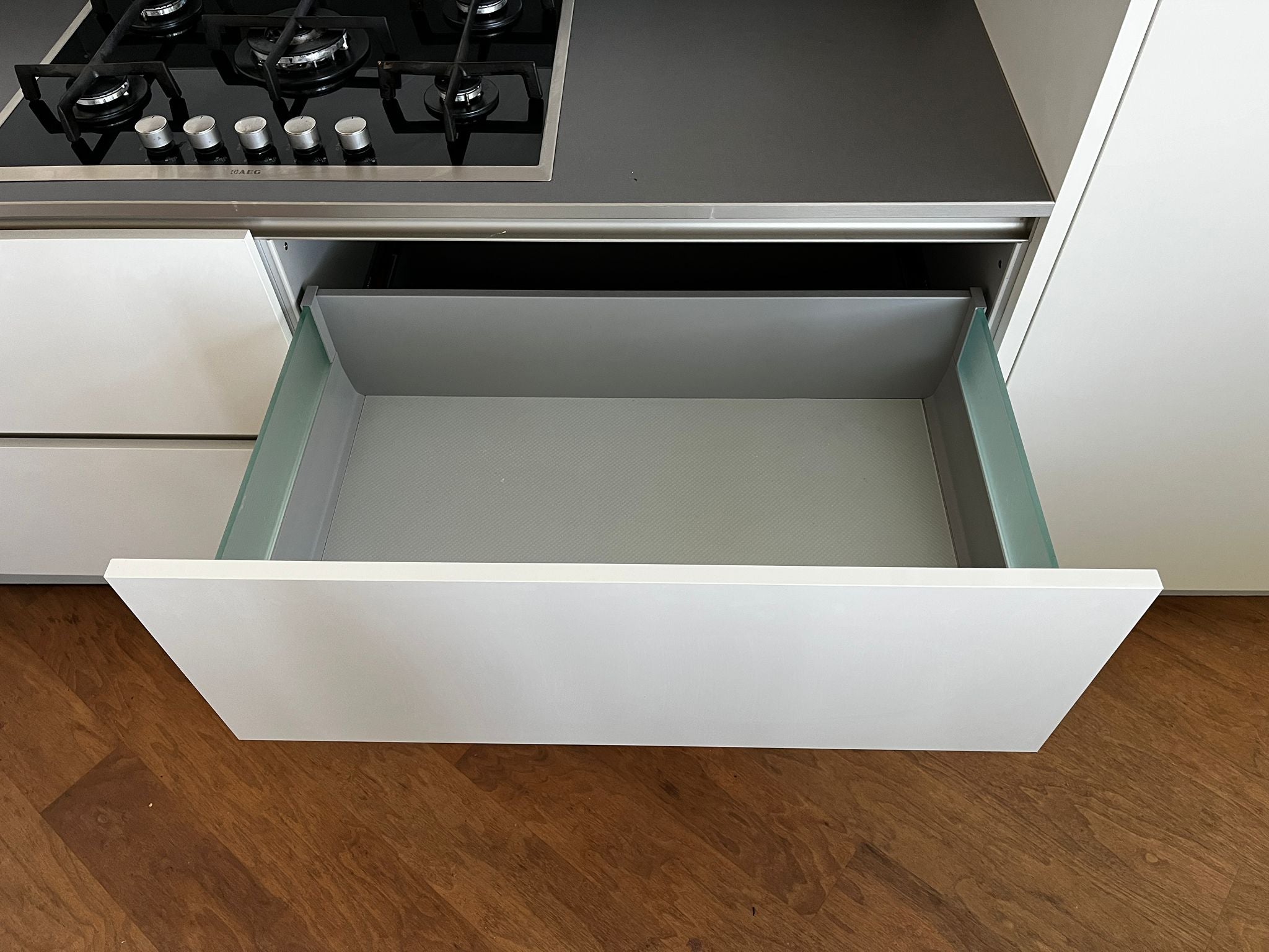 Witte hoekkeuken met ingebouwde AEG apparatuur met witte keukenlade