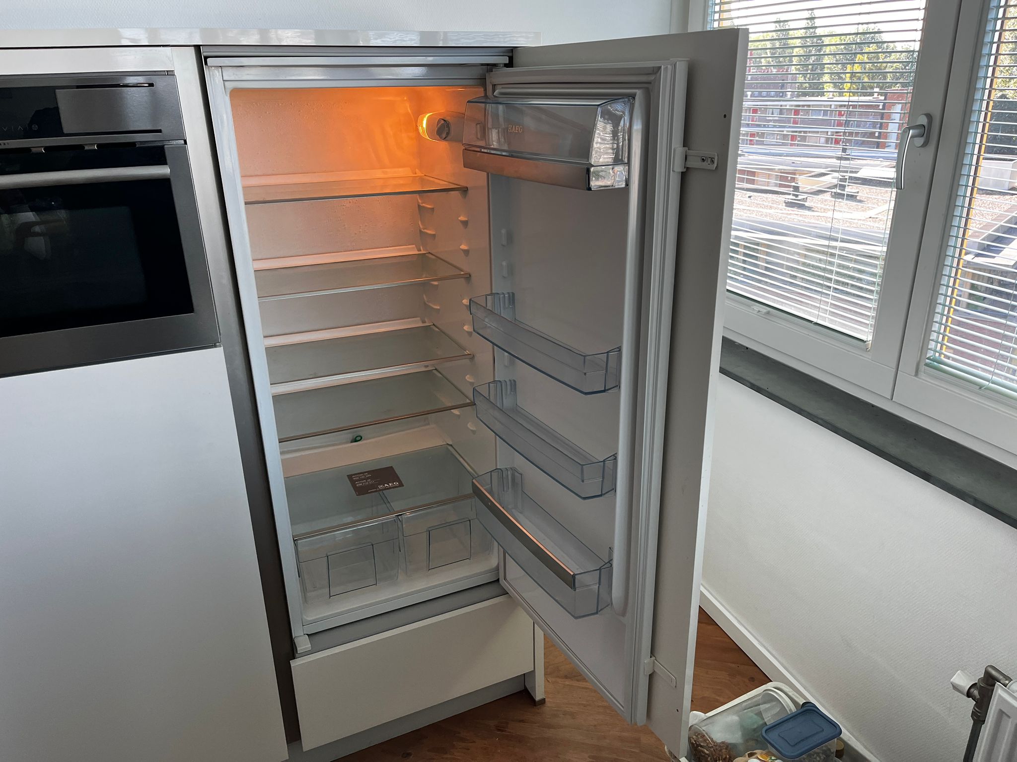 Witte hoekkeuken met ingebouwde AEG apparatuur met witte koelkast van AEG