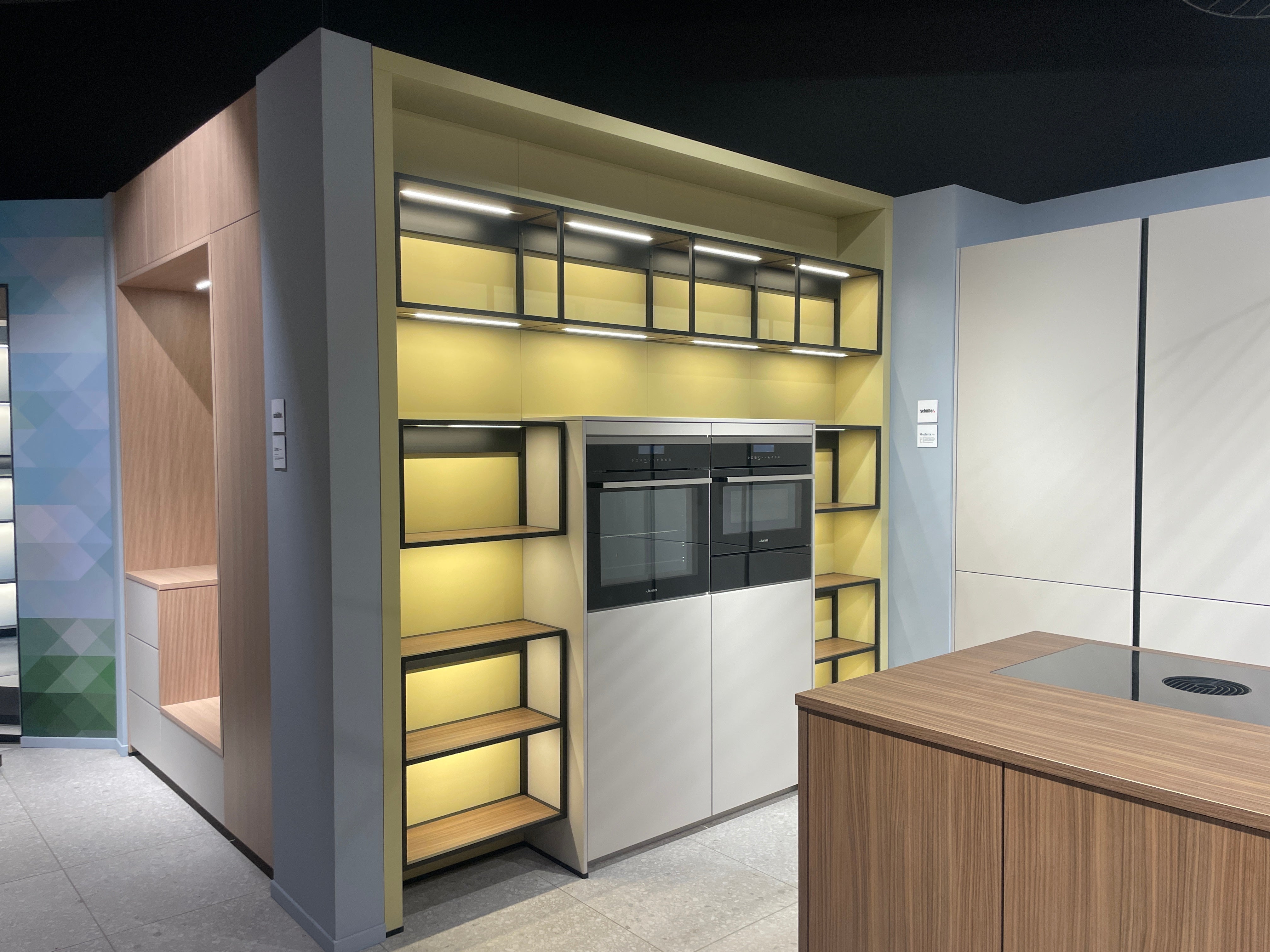 05095 - Moderne Schüller eilandkeuken met kastenwand en verlichte vakkenkast
