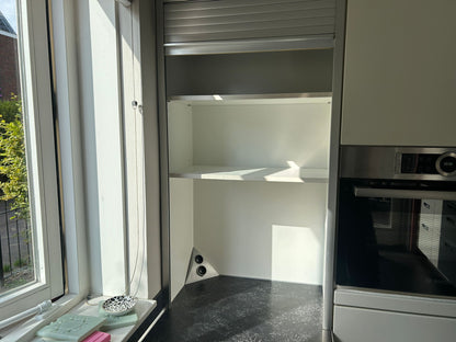 Witte tweedehandse keuken van het merk Alno met een wit schiereiland met een afschermbare kast