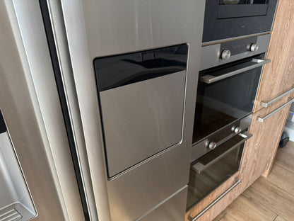 Tweedehandse keuken in houtlook met een grijs kookeiland en kunststoffen blad  met close up van amerikaanse koelkast