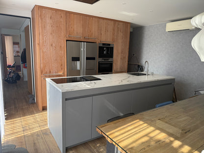 Tweedehandse keuken in houtlook met een grijs kookeiland en kunststoffe blad