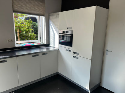 Witte tweedehandse keuken van het merk Alno met een wit schiereiland en een inbouw oven