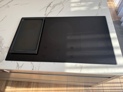 Tweedehandse keuken in houtlook met een grijs kookeiland en kunststoffen blad en inductieplaat