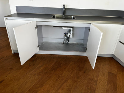 Witte hoekkeuken met ingebouwde AEG apparatuur met een grote kast onder de wasbak