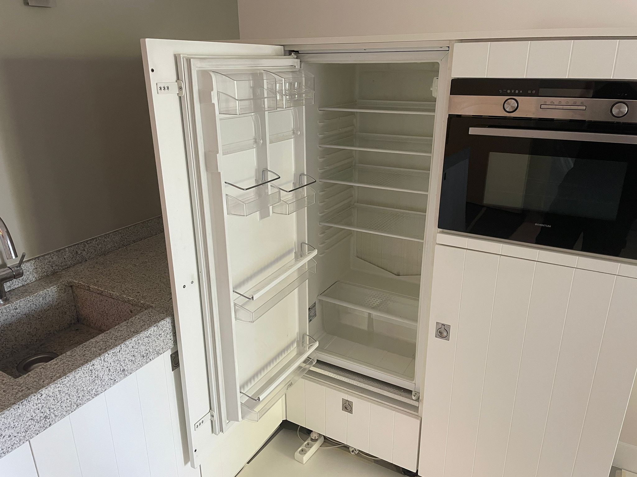 Tweedehands Bruynzeel hoekkeuken in het wit met een werkblad van graniet en koelkast