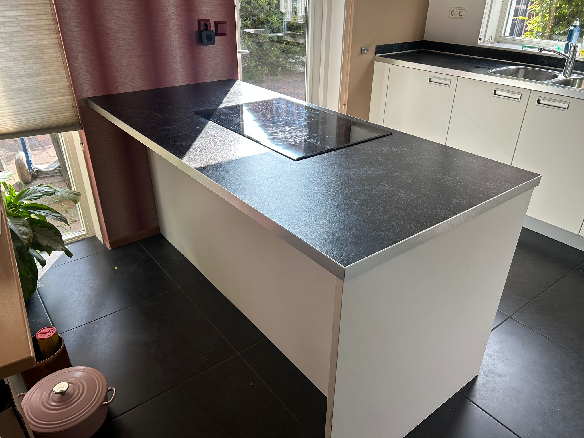 Witte tweedehandse keuken van het merk Alno met een wit schiereiland met stenen blad