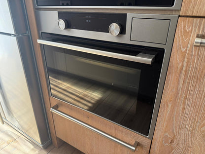 Tweedehandse keuken in houtlook met een grijs kookeiland en kunststoffen blad met twee ingebouwde ovens